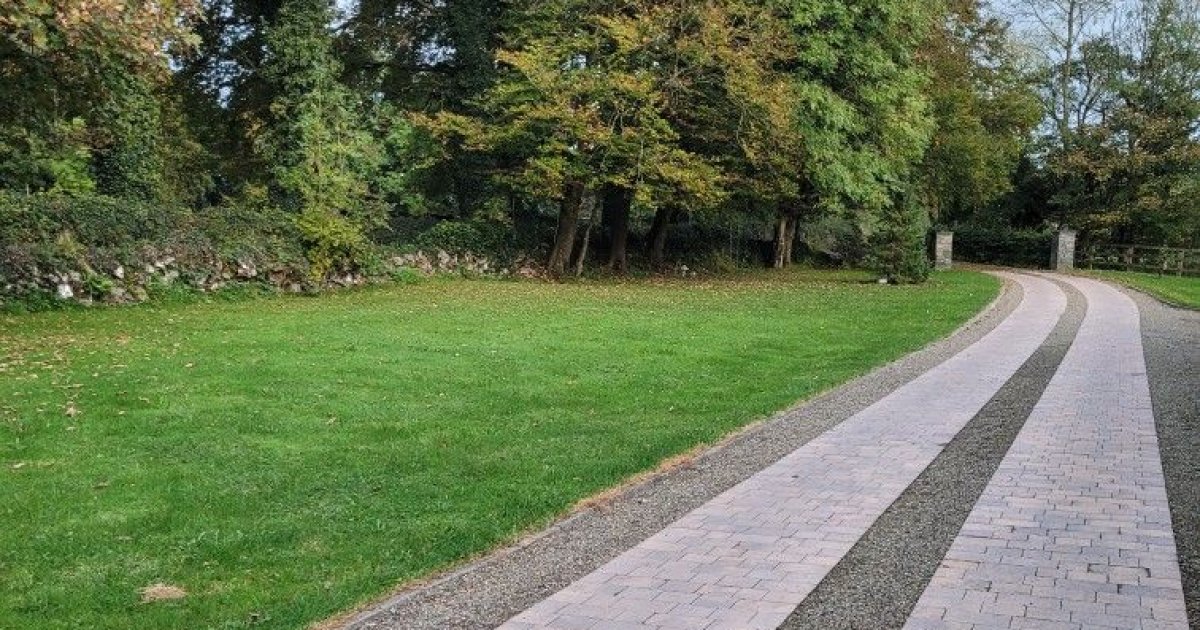 Curved Paver Driveway with Gravel Strips and Tree-Lined Lawn | Builders ...