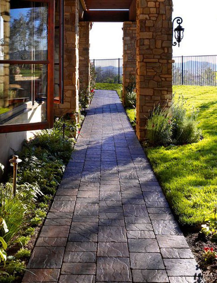 Stone Walkway with Rustic Pillars and Lush Landscaping