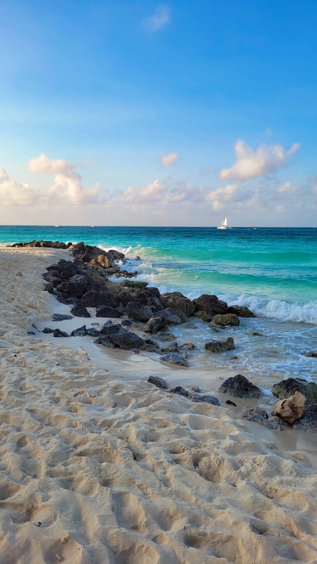 Tranquil Beach with White Sand and Rocky Shoreline