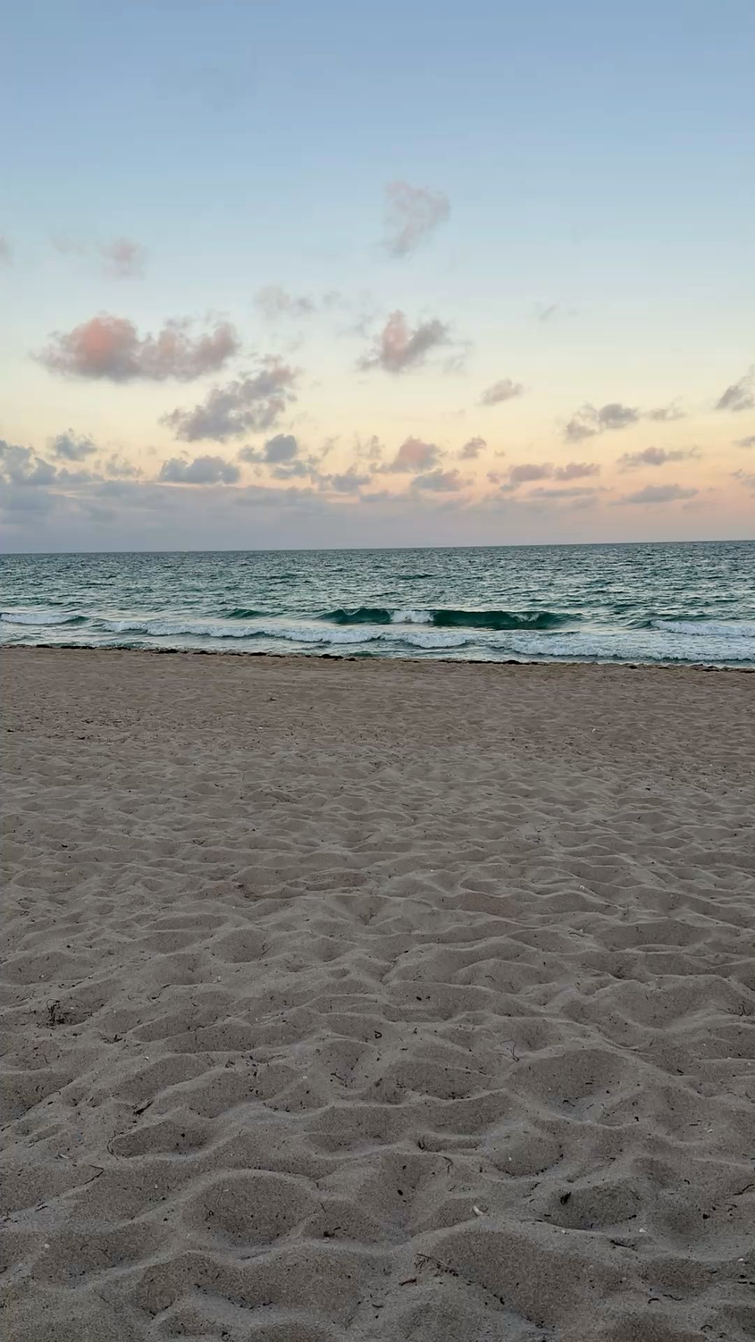 Tranquil Beach at Dawn with Gentle Waves and Soft Pastel Sky