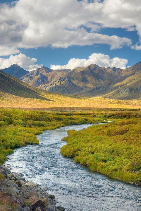 Scenic River Valley with Mountains Under Cloudy Sky